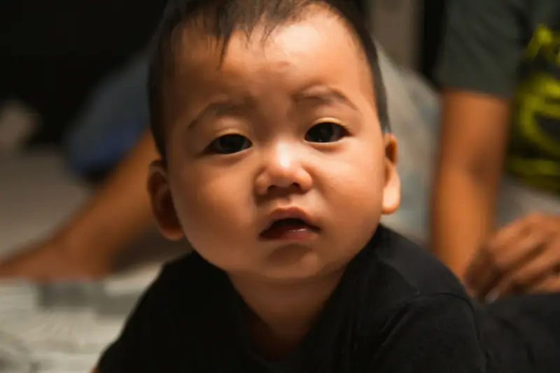 Baby lying awake in cot during 4-month sleep regression with tired expression