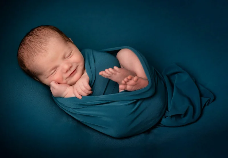 Baby sleeping safely in a sleep sack with arms free — the end goal after transitioning out of swaddle